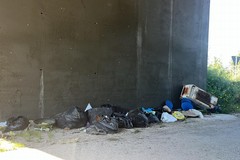 Rifiuti di ogni genere sotto il ponte della strada statale 16 bis