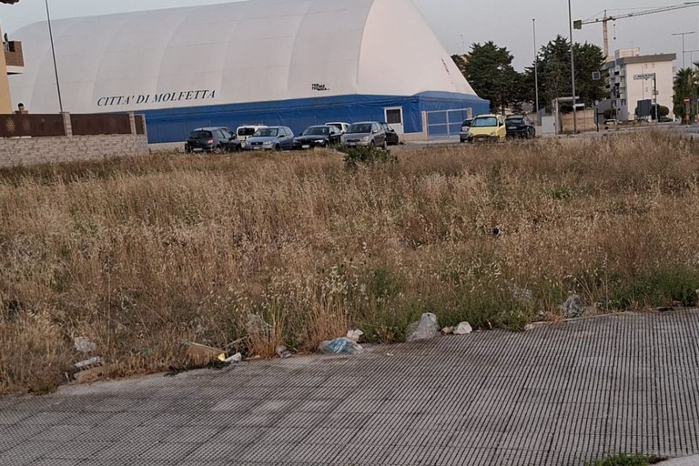Sterpaglie e rifiuti alla rotatoria di via Bettino Craxi