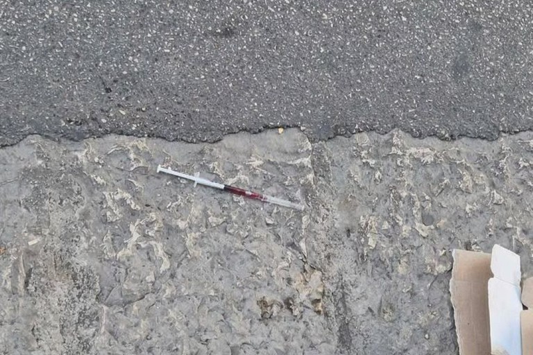 Siringa abbandonata davanti a un portone in via Carlo Alberto